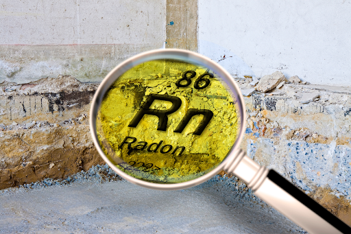 Magnifying glass looking at the radon symbol in black and yellow on a rock wall.