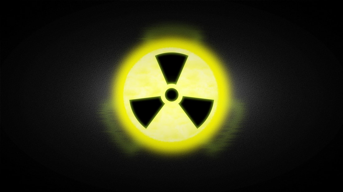 Radioactive symbol in black and yellow and circular with black background.